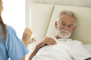 Mężczyzna cierpiący na chorobę Alzheimera w domu pod opieką prywatnej azjatyckiej pielęgniarki